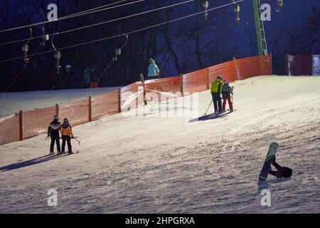 Treffelhausen, Germania - 28 gennaio 2022: Skilift in funzione di notte con illuminazione. Atleti d'inverno sulle piste nella neve. Esposizione prolungata Foto Stock