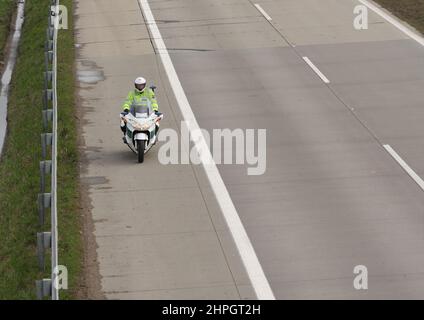 Il poliziotto guida la moto in autostrada a Brno, nella repubblica Ceca, arriva prima prima del convoglio dell'esercito. Foto Stock