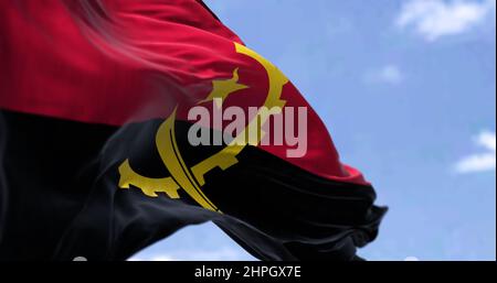 Dettaglio della bandiera nazionale dell'Angola che sventola al vento in una giornata limpida. L'Angola è un paese sulla costa occidentale dell'Africa australe. Messa a fuoco selettiva. Foto Stock