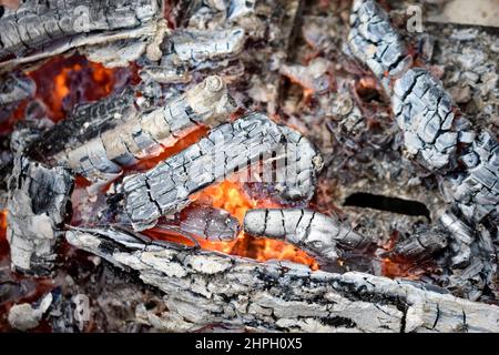 Bruciare i carboni in un fuoco con fiamme Foto Stock