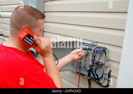 Installazione di TV via cavo e DSL linee e linee telefoniche su casa nuova Foto Stock