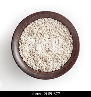 Riso arborio non cotti in ciotola di ceramica isolata su fondo bianco con tracciato di ritaglio Foto Stock