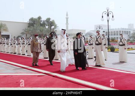 Doha, Doha, Qatar. 21st Feb 2022. Una foto di handout resa disponibile dagli spettacoli dell'ufficio presidenziale iraniano, Qatar Emir Sheikh TAMIM BIN HAMAD al THANI (R) dando il benvenuto al presidente iraniano EBRAHIM RAISI (L) a Doha, Qatar, 21 febbraio 2022. Raisi è in Qatar per una visita ufficiale e per partecipare al vertice del Forum dei paesi esportatori di gas (GECF). (Credit Image: © Iranian Presidency via ZUMA Press Wire) Foto Stock