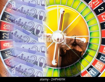 Venti libbre note sulla ruota della roulette con l'uomo con mano sopra faccia. Dipendenza da gioco d'azzardo, industria del gioco d'azzardo, salute mentale... concetto Foto Stock