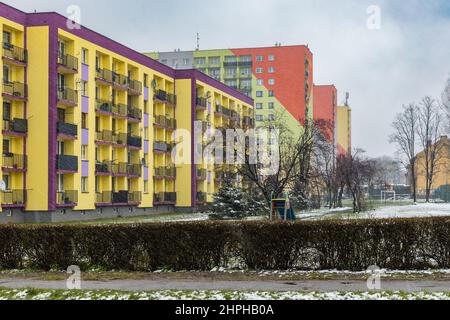 Zawiercie, Polonia - Aprile 2021: Facciata colorata di blocco di appartamenti in giornata nevosa Foto Stock