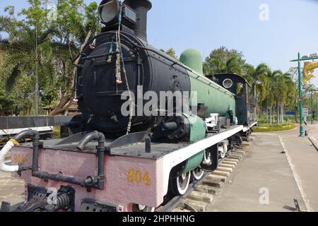 Lato anteriore e sinistro di una vecchia locomotiva nera, verde e rossa che commemora la ferrovia della Birmania tailandese (ferrovia della morte) (immagine orizzontale) Foto Stock