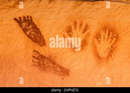 Antichi pittogrammi nativi americani di stampe a mano e a piedi nella zona del Devil's Lane del Needles District del Canyonlands National Park, nello Utah. Th Foto Stock