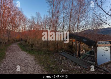 Percorso nei boschi durante un tramonto autunnale con le colline del Prosecco sullo sfondo Foto Stock