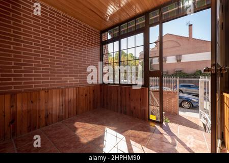 Portico d'ingresso ad una casa singola coperta di legno con una parete in alluminio e vetro Foto Stock