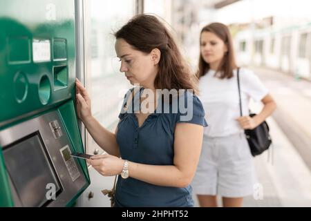 Bella donna traveler acquisto biglietto in metropolitana a biglietto distributori automatici Foto Stock