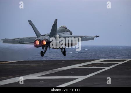 MAR DELLE FILIPPINE (Feb 21, 2022) un F/A-18E Super Hornet, assegnato ai "Vigilantes" di Strike Fighter Squadron (VFA) 151, lancia dal ponte di volo della portaerei di classe Nimitz USS Abraham Lincoln (CVN 72). Abraham Lincoln Strike Group è in fase di implementazione pianificata nell'area delle operazioni della flotta USA 7th per migliorare l'interoperabilità attraverso alleanze e partnership, fungendo da forza di risposta pronta a supportare una regione indopacifica libera e aperta. (STATI UNITI Foto Navy di Mass Communication Specialist 3rd Classe Javier Reyes) Foto Stock