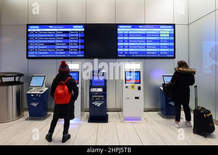 Una persona utilizza un chiosco di biglietti Amtrak situato all'interno della Moynihan Train Hall, New York, NY. Distributori automatici di biglietti senza contanti, pronti contanti a carta Foto Stock