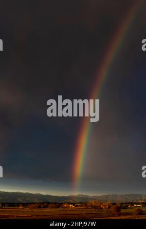 Enorme arcobaleno sulla campagna toscana contro un cielo nuvoloso scuro, Bientina, Pisa, Italia Foto Stock