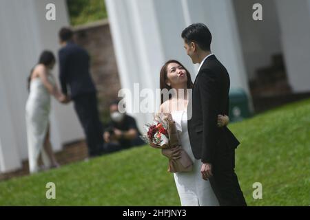 Singapore. 22nd Feb 2022. Una coppia sposata di recente posa per le foto a Fort Canning Park, dopo la registrazione del matrimonio al vicino Registro delle nozze di Singapore il 22 febbraio 2022. 22 febbraio del 2022, una data con numeri di 2s che circa risuonano la pronuncia di 'amore' in cinese parlato, è preferito dalle coppie di registrare il matrimonio per i buoni desideri. Credit: Allora Chih Wey/Xinhua/Alamy Live News Foto Stock