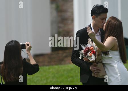 Singapore. 22nd Feb 2022. Una coppia sposata di recente posa per le foto a Fort Canning Park, dopo la registrazione del matrimonio al vicino Registro delle nozze di Singapore il 22 febbraio 2022. 22 febbraio del 2022, una data con numeri di 2s che circa risuonano la pronuncia di 'amore' in cinese parlato, è preferito dalle coppie di registrare il matrimonio per i buoni desideri. Credit: Allora Chih Wey/Xinhua/Alamy Live News Foto Stock