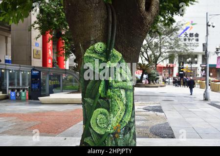 Chongqing, Chongqing, Cina. 22nd Feb 2022. Il 22 febbraio 2022, lo ''zoo'' sull'albero sulla strada pedonale Jiefangbei a Chongqing.recentemente, nel quartiere Jiefangbei di Yuzhong, Chongqing, dove si raccolgono i punti di check-in popolari, uno ''zoo'' su un albero ha iniziato ad attirare l'attenzione. Il reporter ha visto sulla strada di Minzu, strada pedonale di Jiefangbei, che nel mezzo del viale diritto sono due file di ginepro giallo denso alberi. Più di una dozzina di animali, tra cui il ''fulmine'' in ''Zootopia'' e il ''Timan''' meerkat in ''il Re Leone''. I dipinti sono realistici e. Foto Stock