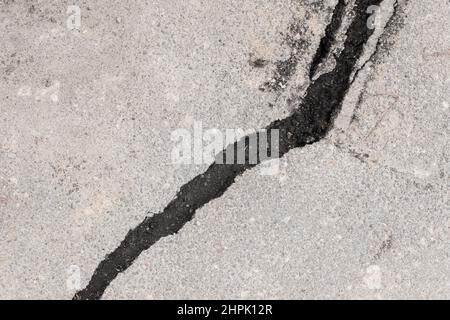 Grande stratificazione delle crepe separazione di asfalto strada rotta pietra danneggiata superficie. Foto Stock