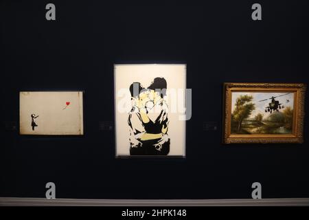 I "Kissing Coppers" di Banksy in mostra durante un'anteprima a Sotheby's, Londra, per la prossima asta di Arte moderna e Contemporanea che presenta £200 milioni di opere d'arte tra cui opere di Magritte, Monet, Picasso, Hockney e tre dell'artista di strada Banksy, dalla collezione di Robbie Williams. Data immagine: Martedì 22 febbraio 2022. Foto Stock