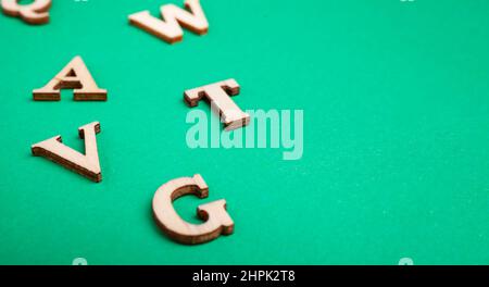 lettere di legno casuali isolate su sfondo verde Foto Stock