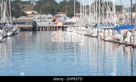 Colorate case di legno su pali, piloni o pilastri, baia o porto, acqua di mare. Vecchio Fisherman's Wharf. Barche a vela, barche a Monterey Marina, California costa USA. Lungomare turistico. Foto Stock