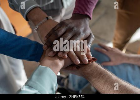 Mucchio di mani di gruppi multietnici di dipendenti contemporanei che simboleggiano partnership, sindacato, team building e spirito aziendale Foto Stock