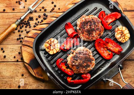 Bistecca di manzo, manzo e maiale marinati in bacche di ginepro. Bistecca tritata tritata sulla griglia Foto Stock