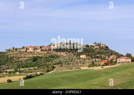 Vista dal basso verso la collina con cipressi e l'antica città di Monticchello in cima. Toscana, Italia Foto Stock