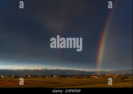 Enorme arcobaleno sulla campagna toscana contro un cielo nuvoloso scuro, Bientina, Pisa, Italia Foto Stock