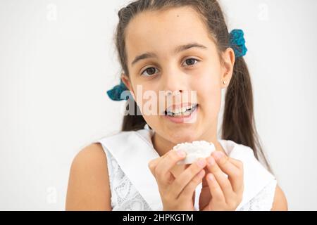 L'adolescente sta tenendo un modello del getto dentale all'inizio del trattamento ortodontico accanto ai suoi denti dopo che il trattamento è stato completato. Foto Stock