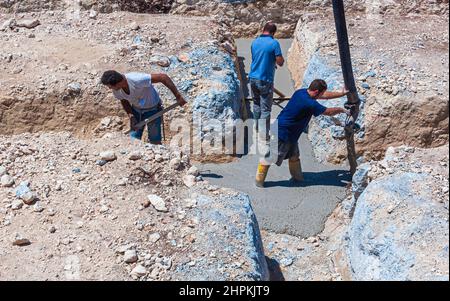 Travaso di calcestruzzo, che dirige la pompa e lavora in fondazioni. Foto Stock