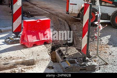 Il lavoratore inserisce cavi in fibra ottica interrati in una micro trincea Foto Stock