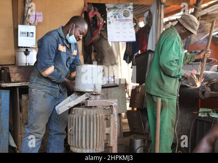 (220222) -- HARARE, 22 febbraio 2022 (Xinhua) -- Revai Feremenga (L) lavora su una rettificatrice mentre il suo collega salda una barra metallica a Magaba, Mbare, Harare, Zimbabwe, febbraio 8, 2022. A molti visitatori, Mbare, che è uno degli insediamenti a basso reddito di Harare, sembra essere una città caotica e sporca. Le strade polverose della zona, gli edifici abitati e i mercati affollati non favoriscono l'insediamento. Nonostante tutto il caos che caratterizza Mbare, uno sguardo più attento rivela che in mezzo a tutto questo caos sono cittadini industriosi che cercano di tutto il loro meglio per estirmi un vivo Foto Stock