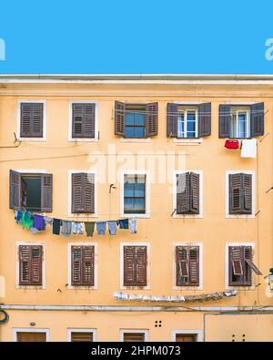 Pittoresca casa residenziale tipica italiana sotto un cielo blu estivo con una nuvola singola Foto Stock