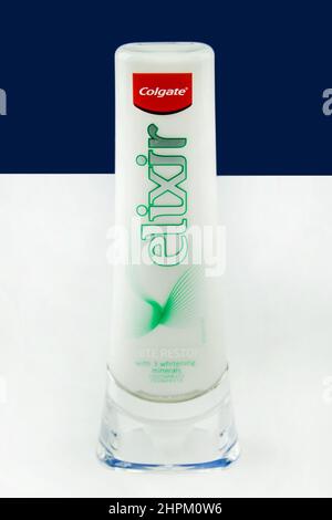 Amburgo, Germania - Febbraio 22 2022: Zahnpflege Colgate Elexir Zahnweiss tubo auf blau weisem Hintergrund - Dental Care Colgate Elixir denti sbiancanti Foto Stock