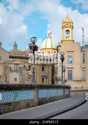 Antico ponte di San Francesco decorato con ceramiche famose nel borgo medievale di Caltagirone, in Sicilia, Italia, con la cupola piastrellata blu della cath di San Giuliano Foto Stock