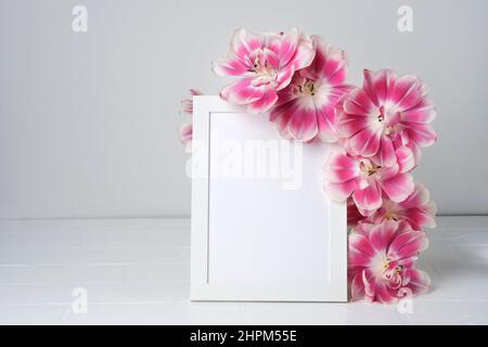 Fiori composizione primavera. Cornice fotografica vuota per testo e tulipano in fiore su sfondo chiaro. San Valentino, Pasqua, Festa della Donna, Festa della Madre, Foto Stock