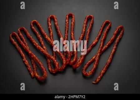 Cabanossi, salsiccia secca isolato su sfondo nero. Foto Stock