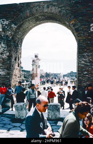 Scansione d'archivio delle rovine del comune di Pompei distrutte dall'eruzione del Vesuvio nel 79 d.C. Turisti sotto l'Arco di Germanico. Scansione di archivio da un vetrino. Agosto 1968. Foto Stock