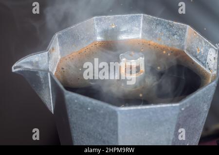 Macchina per il caffè italiana per preparare caffè con fumo e gocce che escono con luce naturale, concetto di colazione. Foto Stock