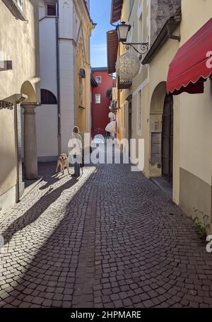 ASCONA, SVIZZERA - 20 GENNAIO 2022: Vita locale in una giornata invernale soleggiata in una stradina del centro storico Foto Stock