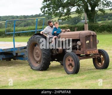 Padre che insegna a figlio di guidare un trattore