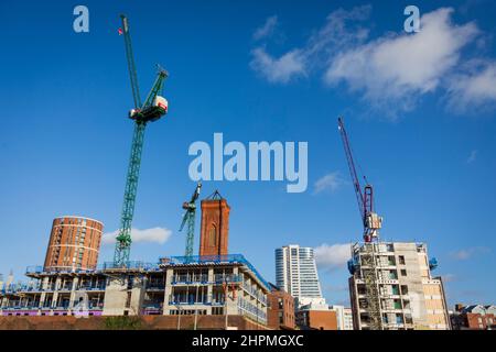 Gru e lavori di costruzione a Leeds, West Yorkshire nella giornata del cielo blu luminoso di febbraio. Leeds ha goduto del più alto livello di attività di costruzione in più di 15 anni l'anno scorso, con la domanda di edifici residenziali che alimenta l'aumento. L’annuale Regional Crane Survey di Deloitte ha mostrato che l’attività di costruzione residenziale è ai massimi livelli, con un totale di 10 nuovi sviluppi in corso per la consegna di 2.267 abitazioni. Credit: Windmill Images/Alamy Live News Foto Stock