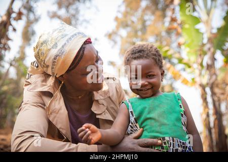 Momento di amore e tenerezza tra madre africana e figlia. Sorridente bambina africana con sua madre. Il concetto del giorno della madre Foto Stock