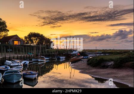 Al tramonto sull'estuario del fiume Glaven con la bassa marea con le barche e i riflessi della nuvola, Blakeney, un piccolo villaggio costiero della costa settentrionale di Norfolk, Inghilterra Foto Stock