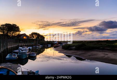 Al tramonto sull'estuario del fiume Glaven con la bassa marea con le barche e i riflessi della nuvola, Blakeney, un piccolo villaggio costiero della costa settentrionale di Norfolk, Inghilterra Foto Stock