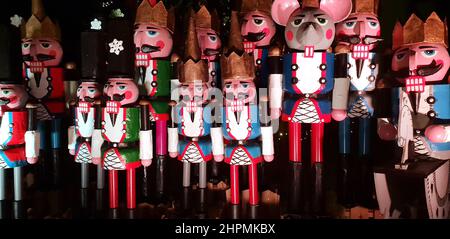 Statue in legno di nutcracker in piedi in fila come decorazione di Natale, foto di notte Foto Stock
