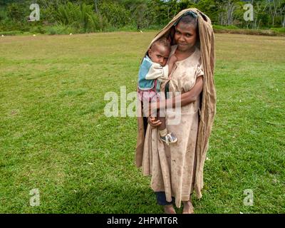 Madre e neonato in montagna della Provincia delle Highland Orientali, Papua Nuova Guinea. La madre indossa una copertura di testa tessuta e assomiglia alla madonna. Foto Stock