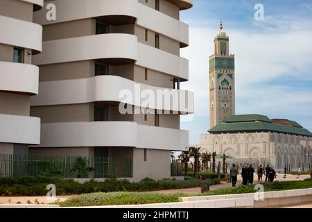 La Moschea di Hassan II sorge accanto a edifici di appartamenti contemporanei sul lungomare di Casablanca, Marocco. Foto Stock