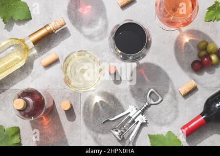 Vino rosso, bianco e rosato in calici da vino su fondo in cemento. Vista dall'alto. Concetto di bevanda e vino. Foto Stock
