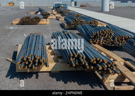 Sparo orizzontale di pile di barrette in acciaio su pallet in legno in un nuovo cantiere industriale. Foto Stock